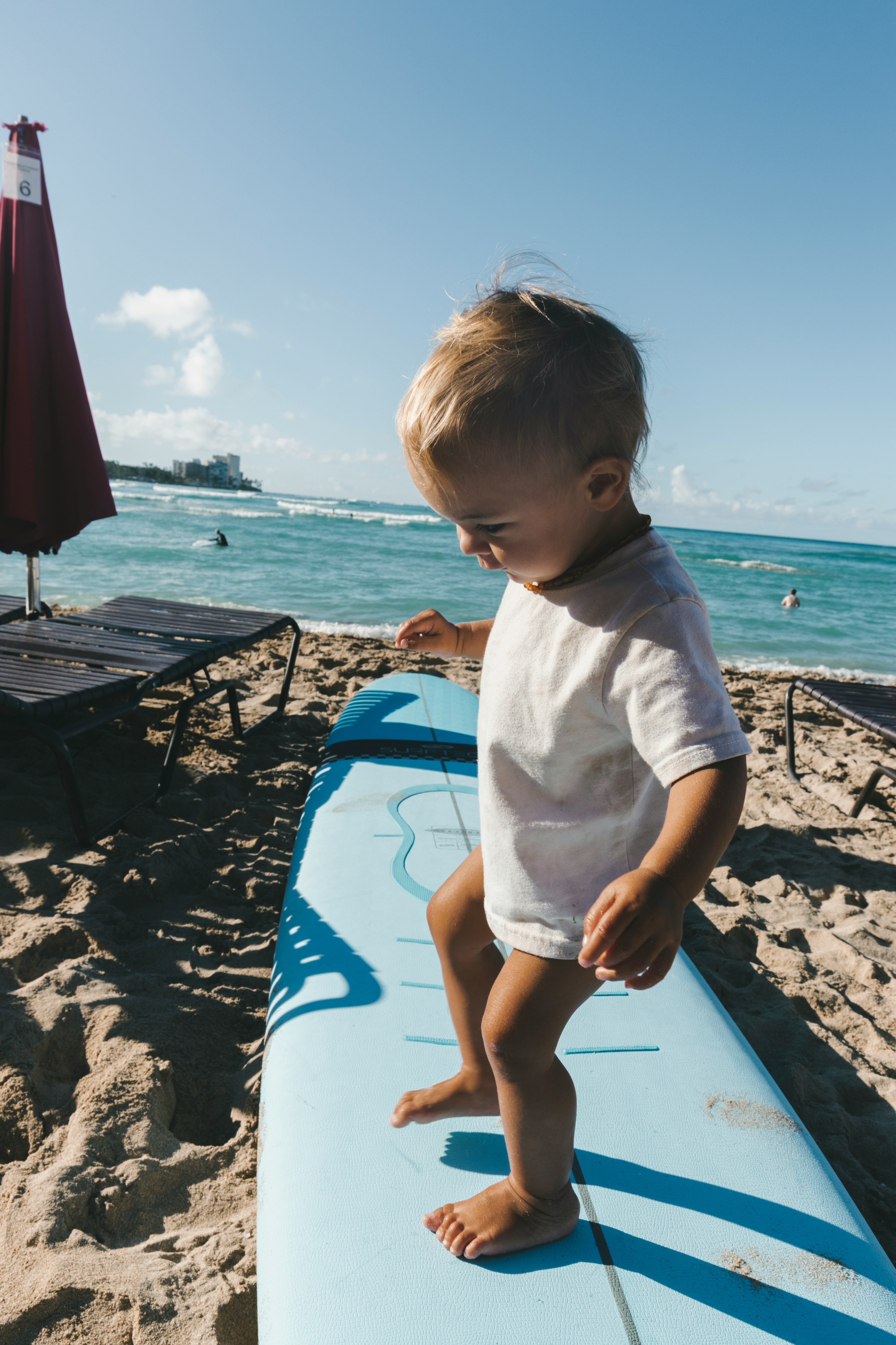 Beginner surfers catching a small wave on a Kauaʻi beach